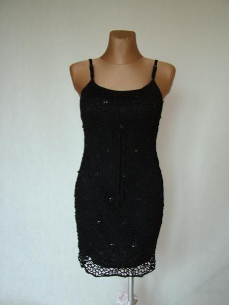 Czarne, koronkowe mini na ramiączkach, eksponowane na manekinie z cielistego tworzywa, z delikatnymi cekinami i ozdobnym wykończeniem dołu.