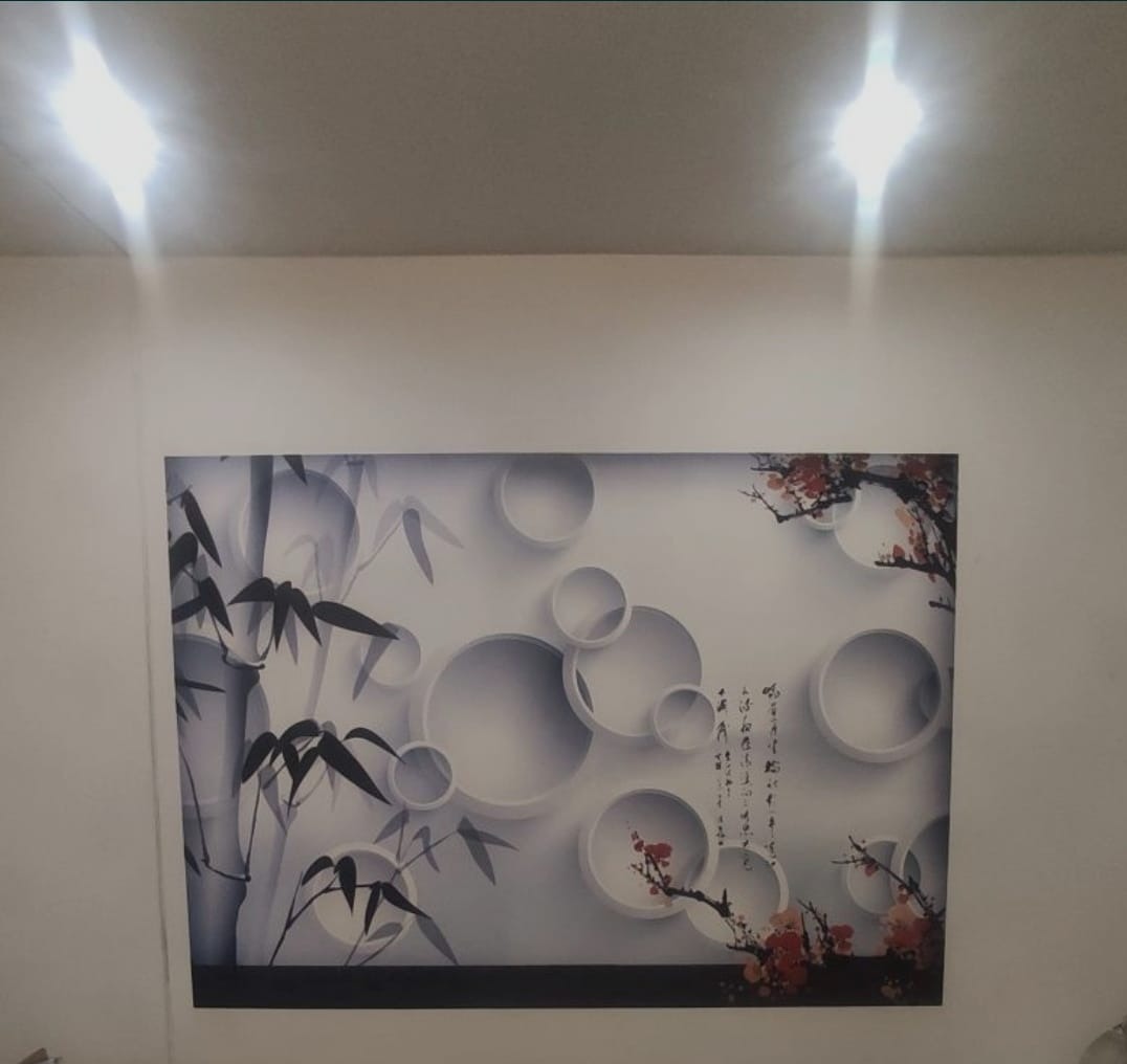 Fototapeta z motywem bambusa, białych okręgów i kwitnącej wiśni japońskiej na ścianie w pokoju, oświetlona od góry dwoma punktowymi lampami.
