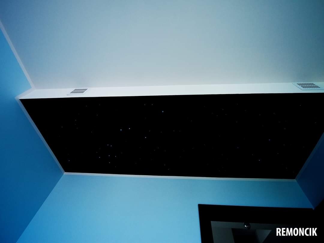 Niebieski pokój z sufitem imitującym nocne niebo z gwiazdami; widoczne kratki wentylacyjne.