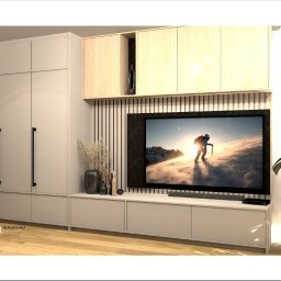 s'Kubana Anna Skrobisz-Bujanowska - Wizualizacja salonu z zabudową meblową: szafa z długimi czarnymi uchwytami, szafki wiszące z jasnego drewna, podłużne lamele na ścianie za telewizorem w czarnej ramie, na szafce pod telewizorem...