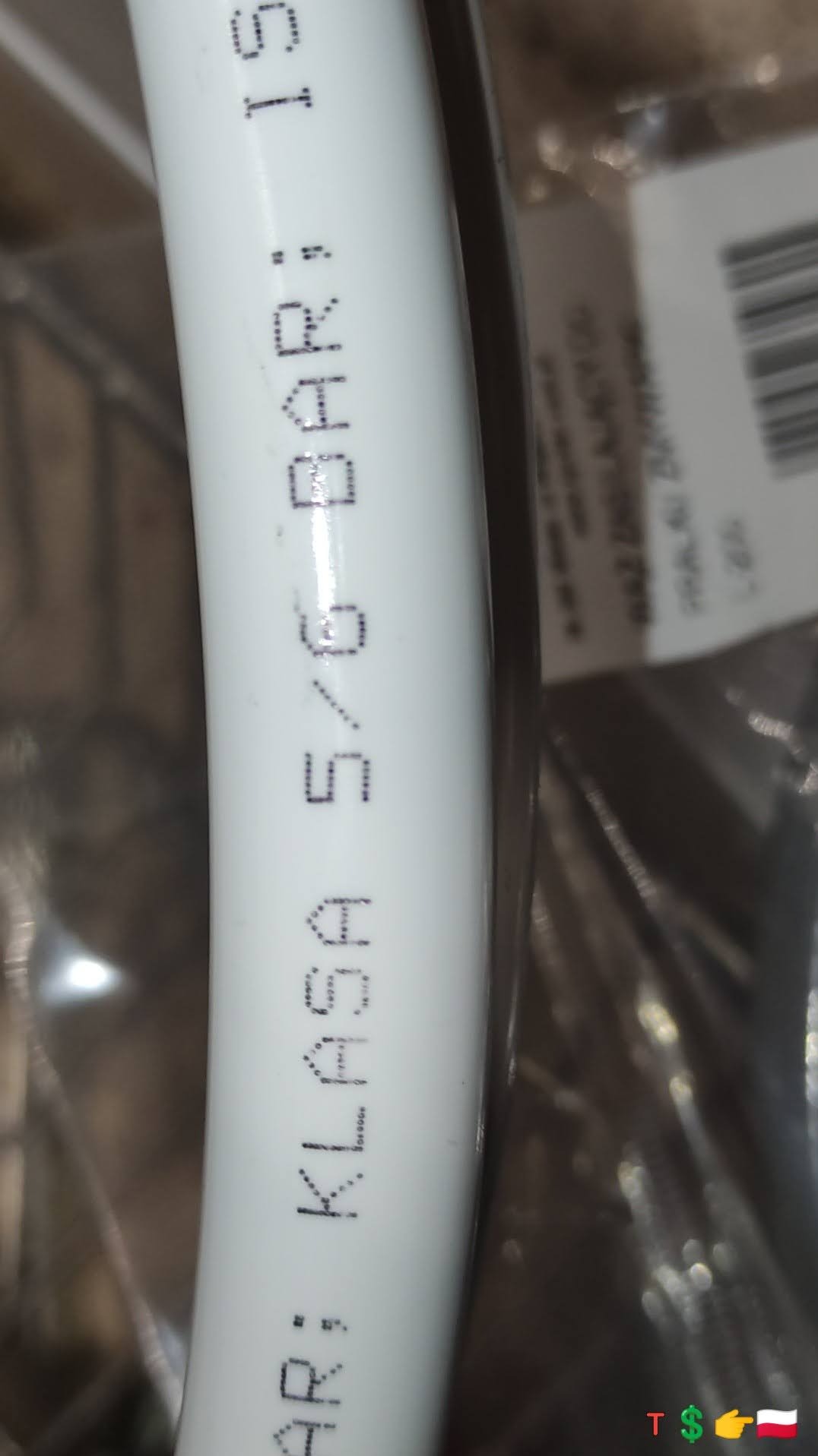 Fragment białej rury z nadrukowanym tekstem 'KLASA 5/6 BAR: 15', widoczne detale oznaczeń technicznych.