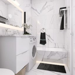 Krzysztofa Florczak Kreatywne Studio - Biała łazienka z marmurowymi płytkami, pralką zabudowaną w szafce pod umywalką, oświetleniem LED i czarnymi akcentami w postaci ręczników i dywanika.