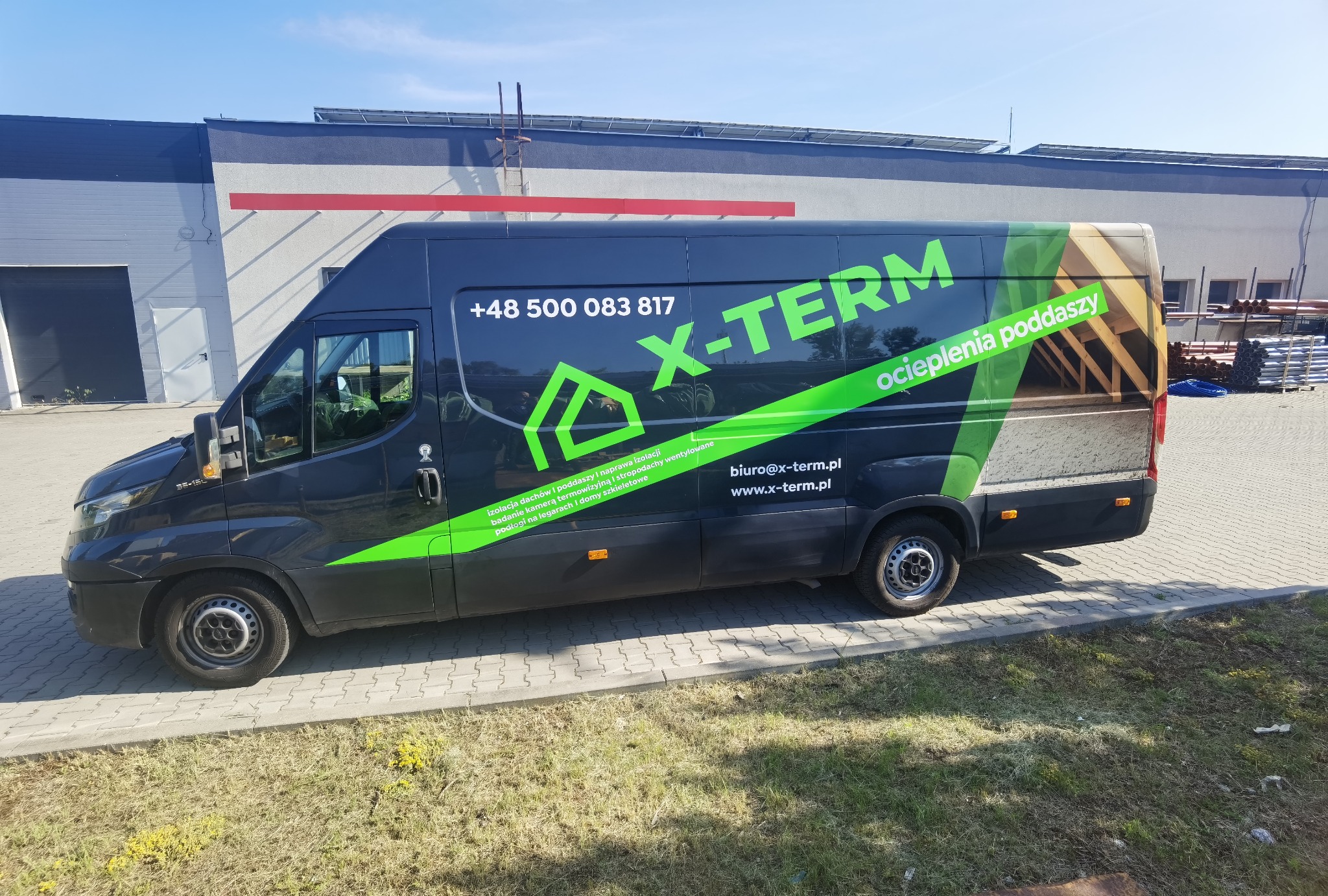 Czarny bus z zielonym logo X-Term i numerem telefonu +48 500 083 817. Reklama usług ocieplania poddaszy, izolacji dachów i stropodachów wentylowanych.