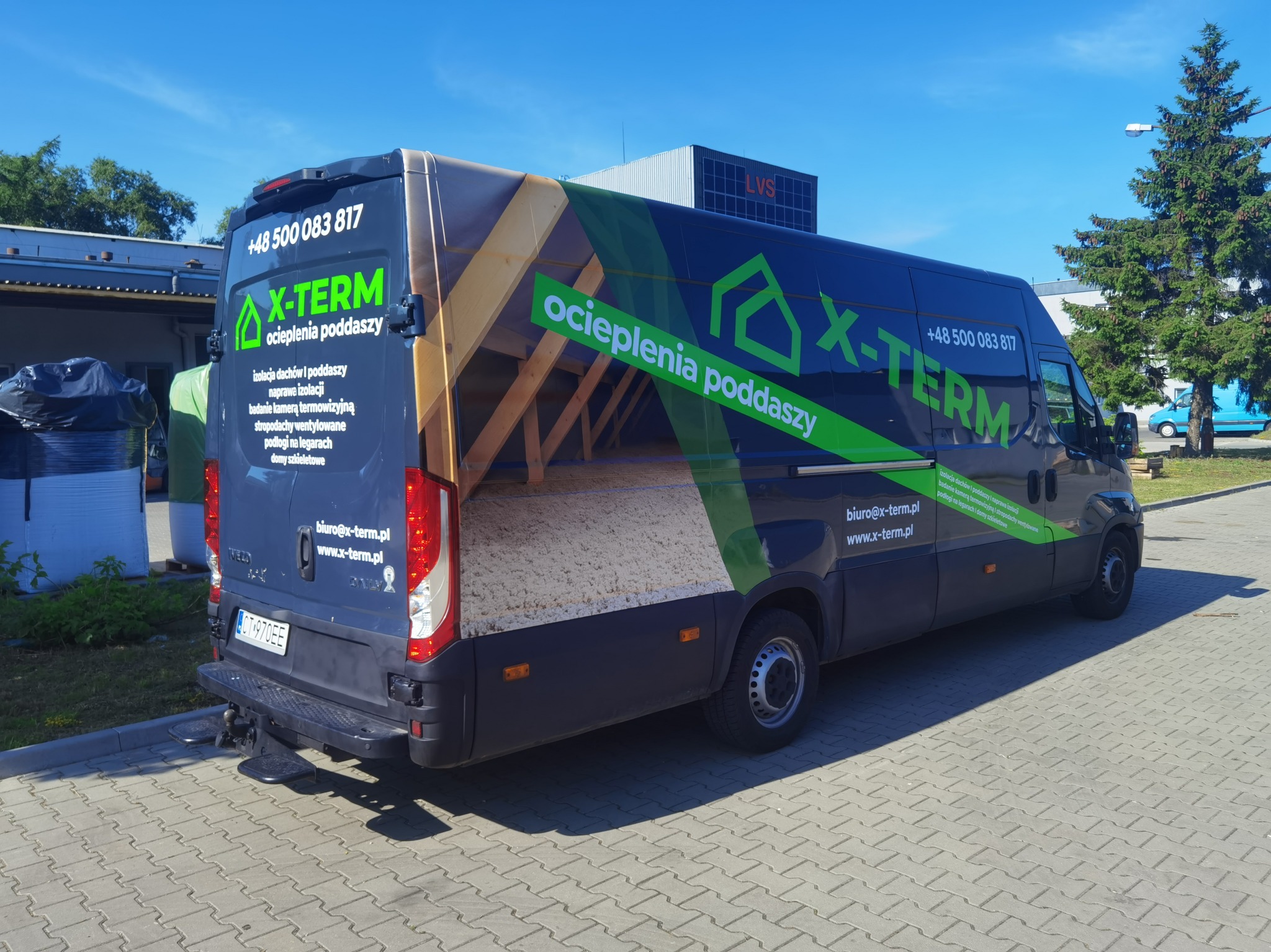 Oklejony van z grafiką ocieplenia poddaszy X-TERM, z widoczną strukturą dachu i izolacją. Numer telefonu i adres strony na ciemnym tle pojazdu.