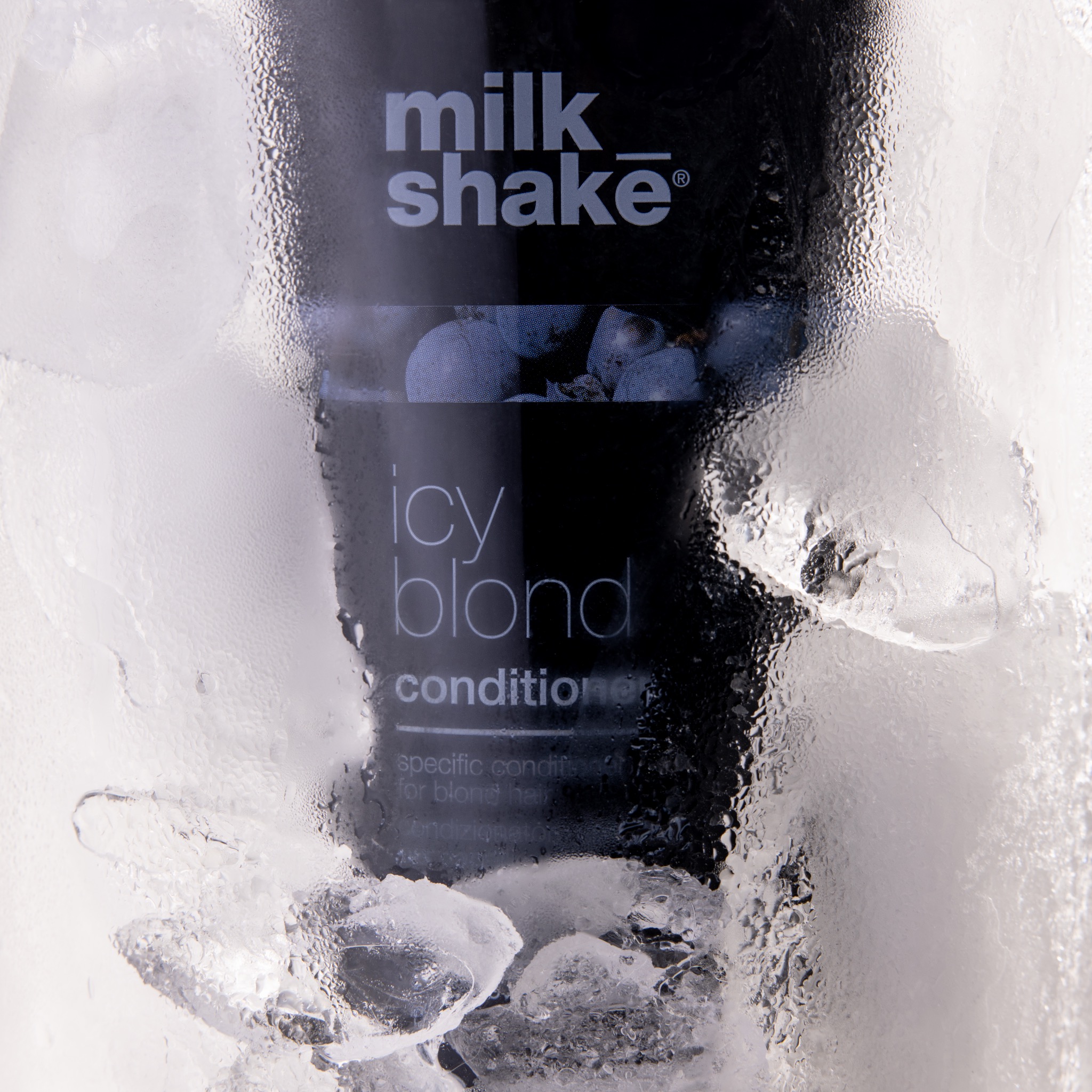 Butelka czarnego kondycjonera do włosów Milk Shake Icy Blond otoczona kostkami lodu i kroplami wody, ukazująca chłodny efekt produktu.
