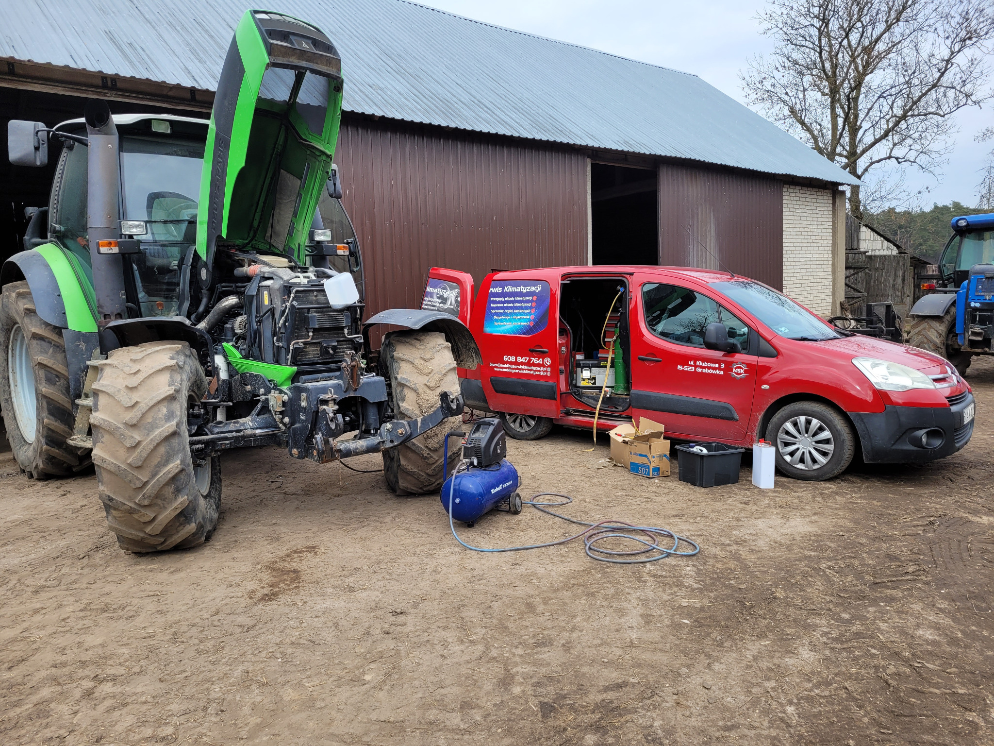 Serwis klimatyzacji mobilnej przy zielonym traktorze Deutz-Fahr, z otwartą maską, oraz czerwonym samochodzie serwisowym Citroen Berlingo z reklamą firmy Rwis Klimatyzacji na tle budynku gospodarczego.