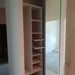 Rafal Sarnowski - Szafa na ubrania w korytarzu z drzwiami przesuwnymi i miejscem na buty.