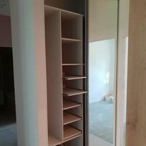 Szafa na ubrania w korytarzu z drzwiami przesuwnymi i miejscem na buty.