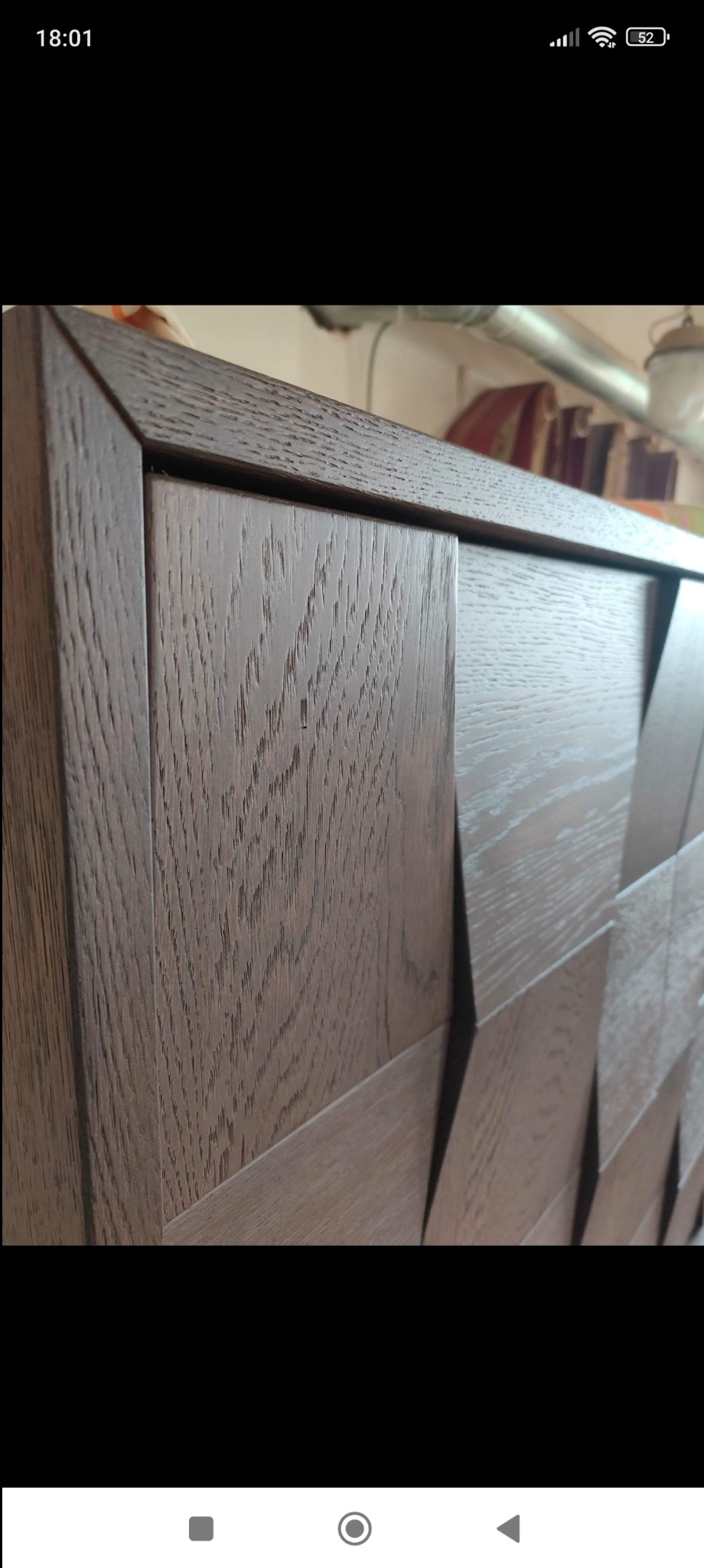 Fragment szafy z ciemnego drewna z geometrycznym wzorem 3D na frontach, widoczne usłojenie drewna i precyzyjne połączenia elementów.