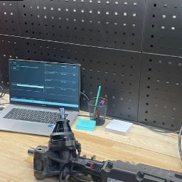 MAGLO - Diagnostyka samochodowa: Dwa laptopy z oprogramowaniem diagnostycznym, moduł sterujący i tester diagnostyczny Autel na stole w warsztacie.