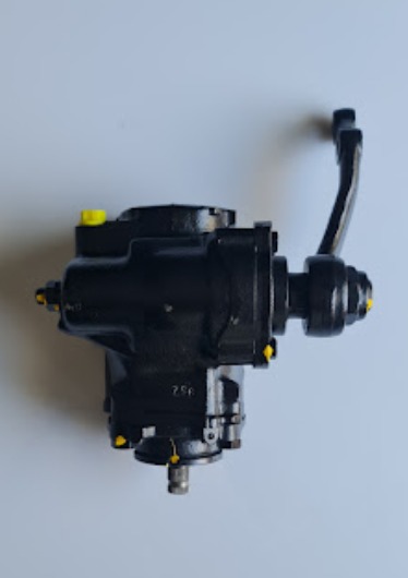 Czarna przekładnia kierownicza z żółtymi detalami, widoczna na jednolitym tle.