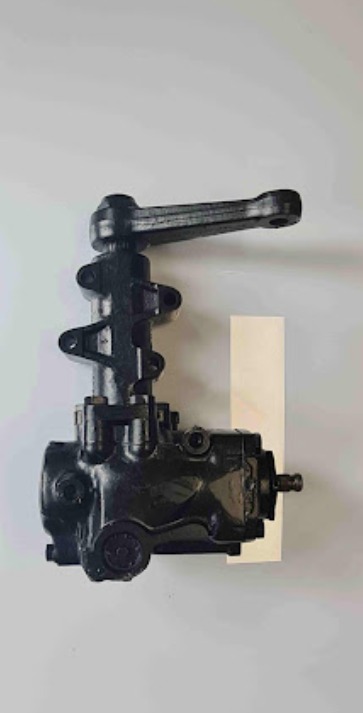 Czarna, odnowiona przekładnia kierownicza na jasnym tle, widoczne ślady po renowacji.