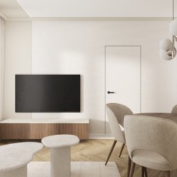 Katarzyna Wysopal - Jasne wnętrze salonu z drewnianym stołem i krzesłami, telewizorem na ścianie i designerskim oświetleniem. Minimalistyczny wystrój z parkietem w jodełkę.