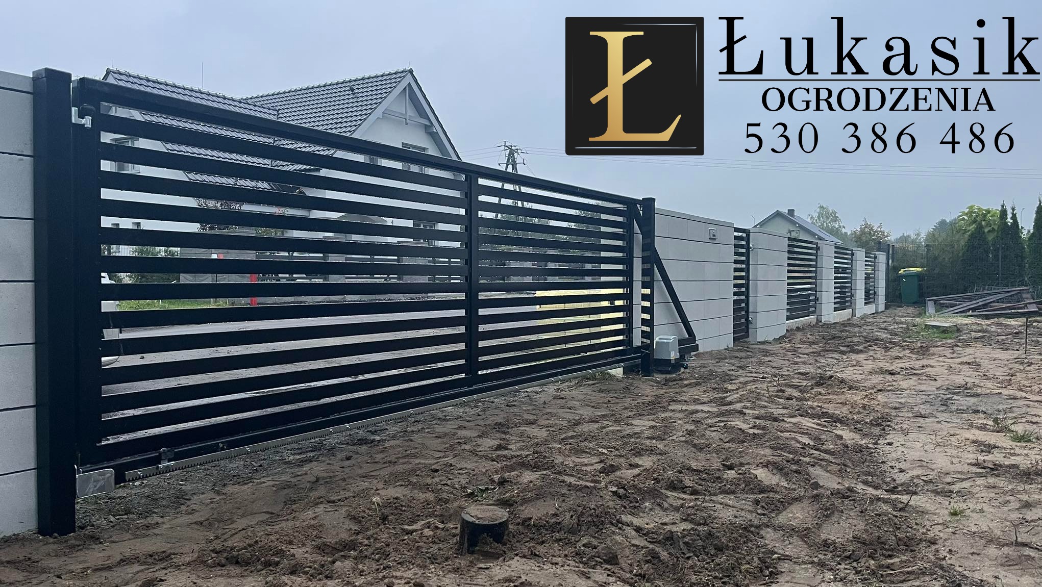 Automatyczna brama przesuwna z poziomych profili, szara podmurówka z logo firmy Łukasik Ogrodzenia i numerem telefonu, teren po montażu.