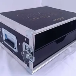 Profesjonalna, czarna skrzynia transportowa z aluminiowymi okuciami i wysuwaną szufladą, z widocznym logo i numerem telefonu na górnej powierzchni.