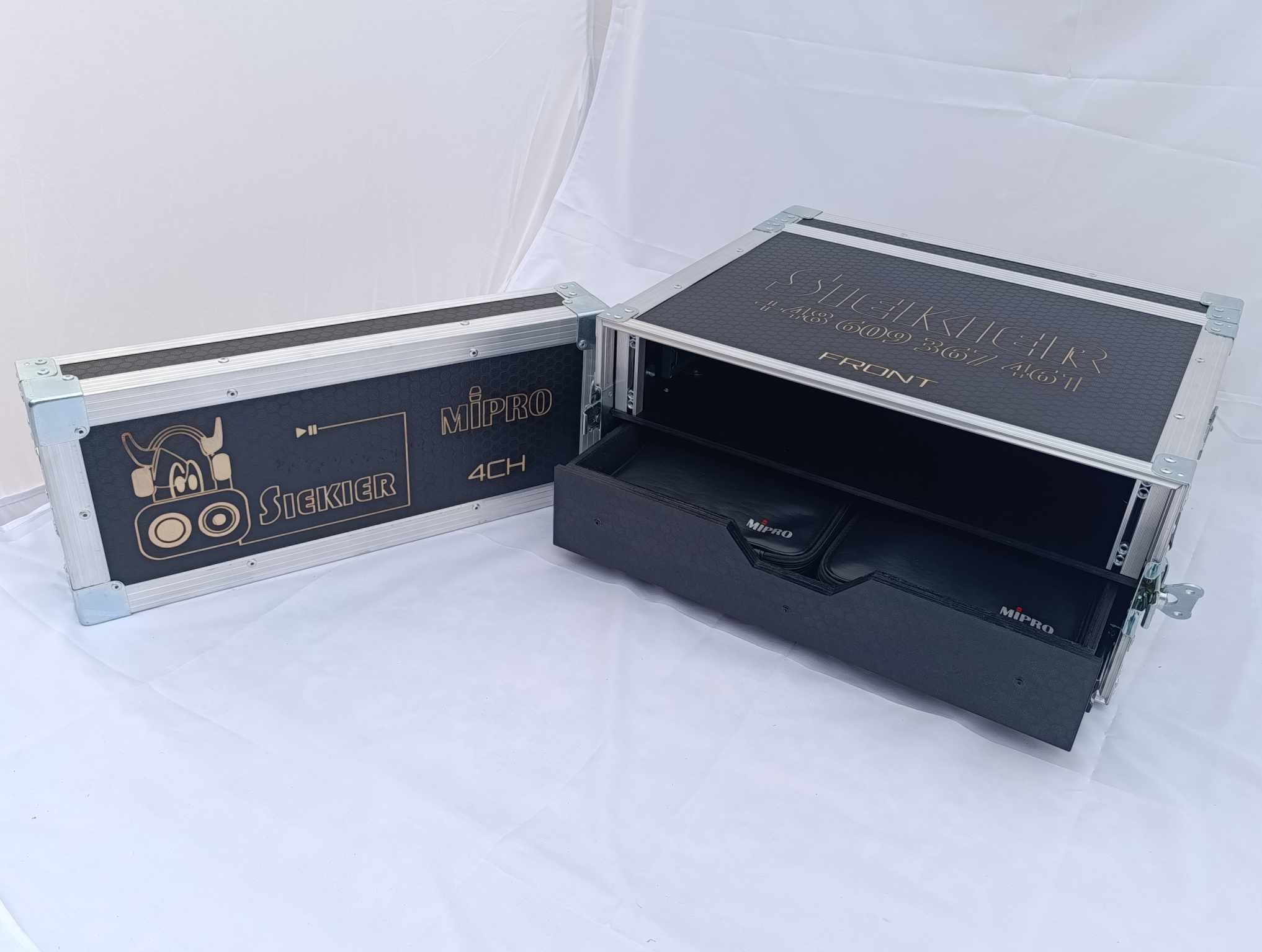 Otwarty case transportowy z logiem Siekier i MiPro, zawierający szufladę z akcesoriami mikrofonowymi, na białym tle.