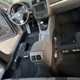 Wnętrze samochodu marki Volkswagen we Wrocławiu, z widocznym odkurzonym dywanem podłogowym po demontażu foteli, przygotowane do dalszych prac.