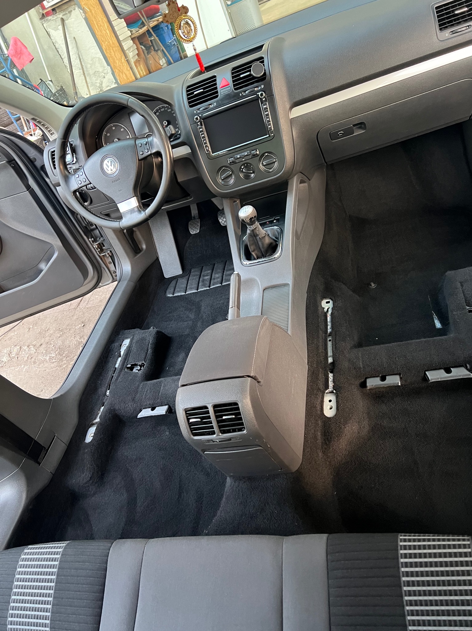 Wnętrze samochodu marki Volkswagen we Wrocławiu, z widocznym odkurzonym dywanem podłogowym po demontażu foteli, przygotowane do dalszych prac.