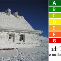 Budynek pokryty grubą warstwą szronu i śniegu, z widocznymi oknami i kominami, na tle błękitnego nieba; po prawej stronie grafika z klasami energetycznymi budynku A-G oraz dane kontaktowe firmy.