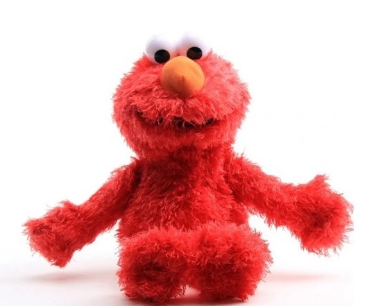 Czerwona pluszowa zabawka Elmo z Sesame Street na białym tle, z pomarańczowym nosem i dużymi białymi oczami.