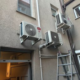 KLIM - MAR Mariusz Bogajczyk - Trzy klimatyzatory różnych marek (TCL, Altech, LG) zamontowane na elewacji budynku, widoczna drabina oparta o ścianę.