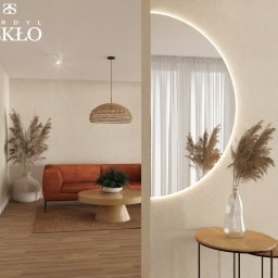Sordyl Szkło - Nowoczesne wnętrze z okrągłym lustrem z podświetleniem LED, odbijającym część salonu z pomarańczową sofą i drewnianym stolikiem kawowym.