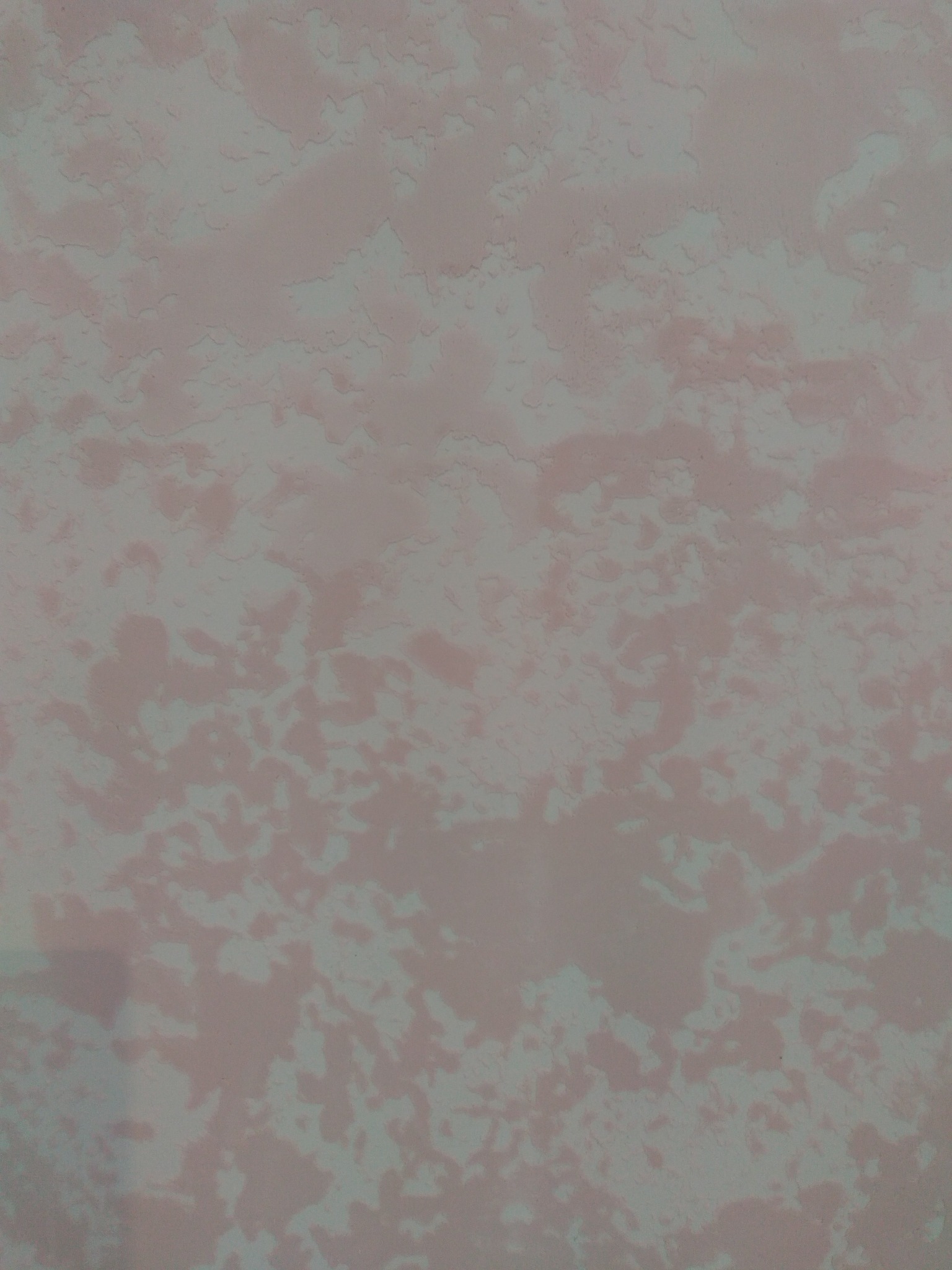 Tekstura ściany z efektem malowania chmurkowego w odcieniach różu i szarości, imitująca naturalne wzory.