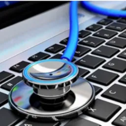 Stetoskop z niebieskim przewodem leżący na klawiaturze laptopa z aluminiową obudową, symbolizujący diagnostykę i serwisowanie sprzętu komputerowego.