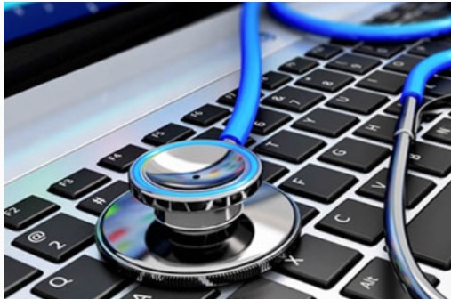 Stetoskop z niebieskim przewodem leżący na klawiaturze laptopa z aluminiową obudową, symbolizujący diagnostykę i serwisowanie sprzętu komputerowego.