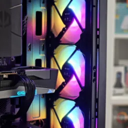 Wnętrze komputera stacjonarnego z trzema podświetlanymi wentylatorami RGB marki Fury, karta graficzna Gigabyte z niebieskim podświetleniem, widoczne kable w oplocie.