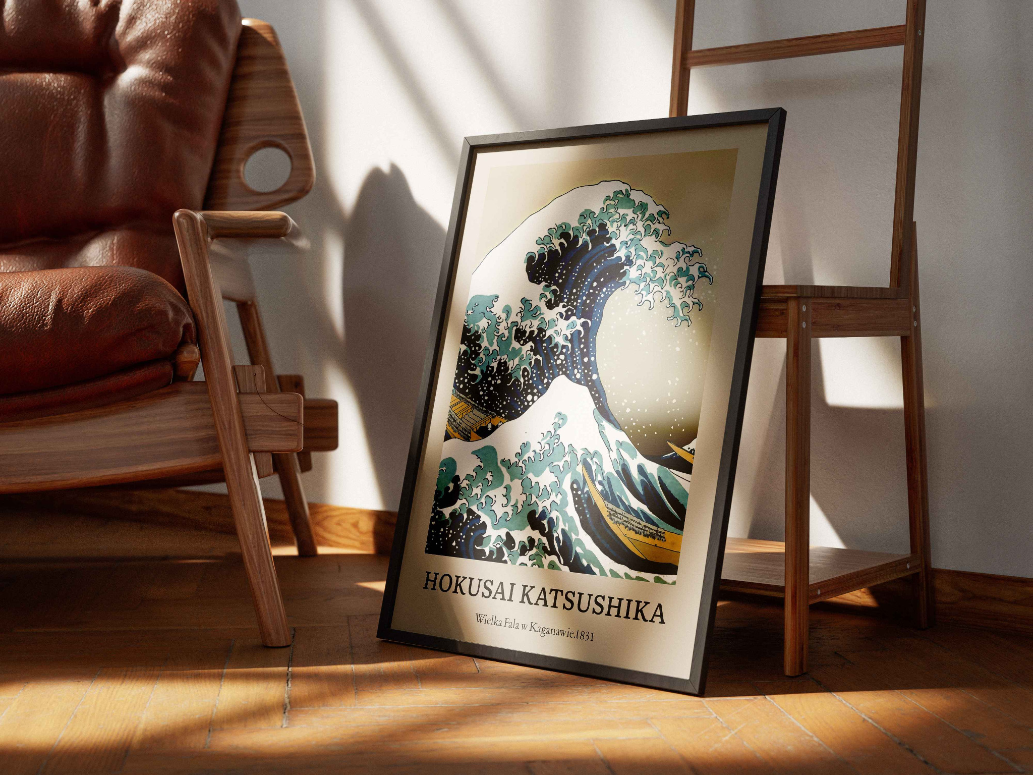 Oprawiony plakat z motywem 'Wielkiej Fali' Hokusai Katsushika, stojący na podłodze w Bedlnie, oświetlony popołudniowym słońcem, obok drewnianego krzesła i drabiny.