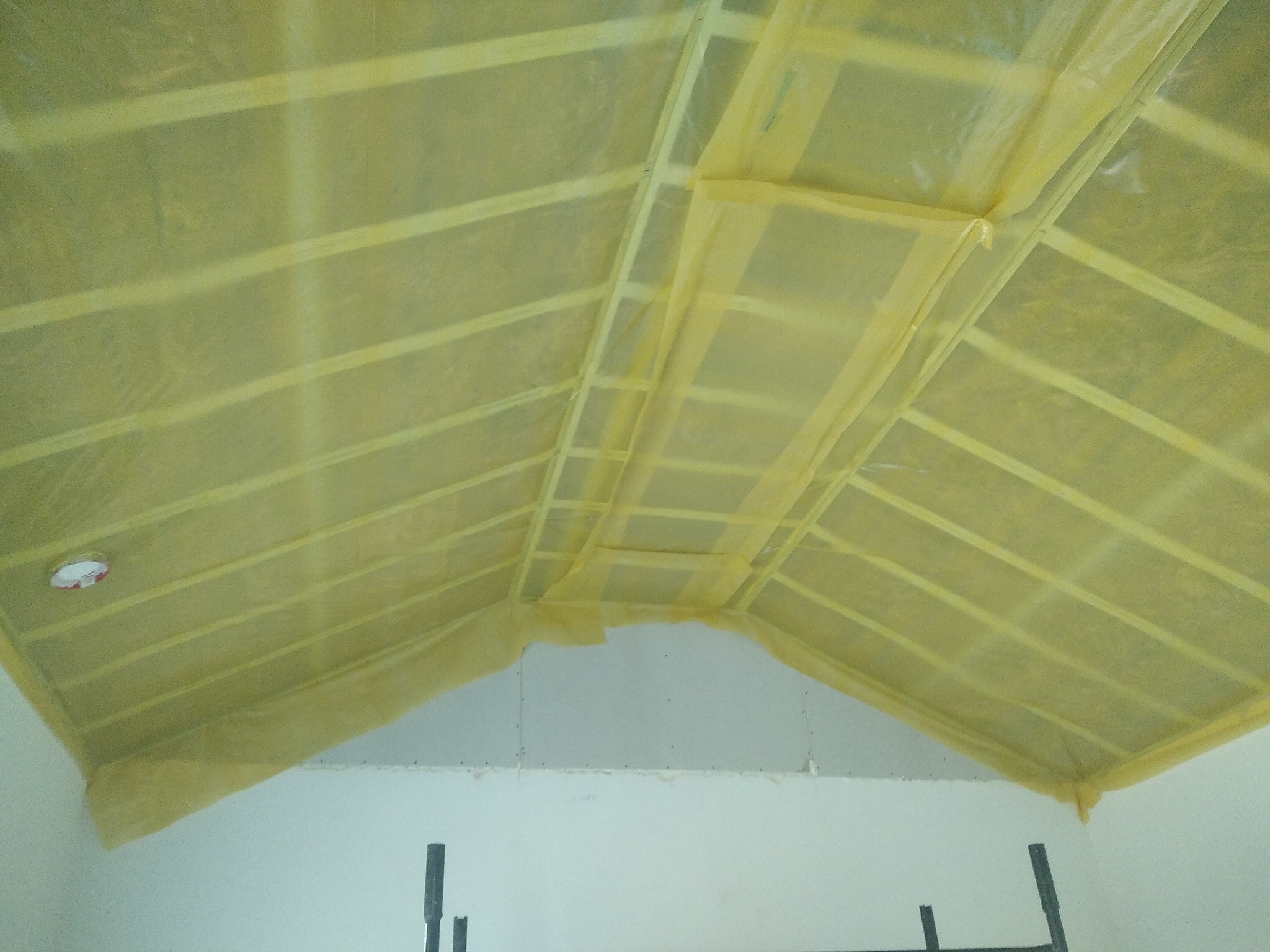 Sufit podwieszany z płyty karton gips zabezpieczony folią malarską, widoczne profile i łączenia płyt na poddaszu.