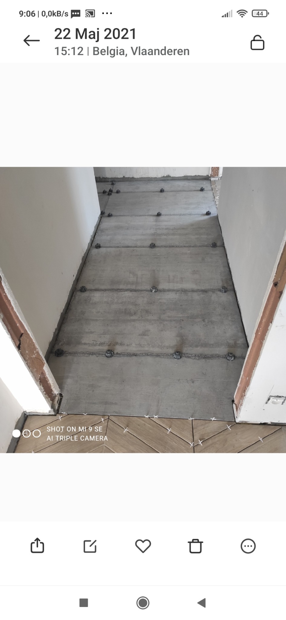 Wyrównywanie podłogi wylewką samopoziomującą z użyciem poziomujących nakrętek i listew, częściowo wyłożona płytkami w jodełkę przy wejściu do pomieszczenia.