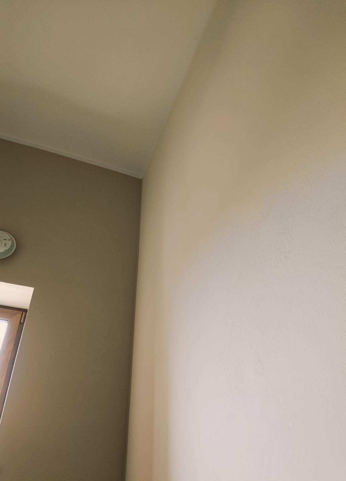 Pomieszczenie po malowaniu ścian na dwa kolory: beżowy i kremowy, widoczny fragment okna i zegara.