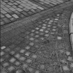 PPHU PIT-GRAN - Ujęcie z góry na nawierzchnię z kostki brukowej, gdzie krzyżują się różne wzory ułożenia, a w tle widoczne przejście dla pieszych z białymi pasami.