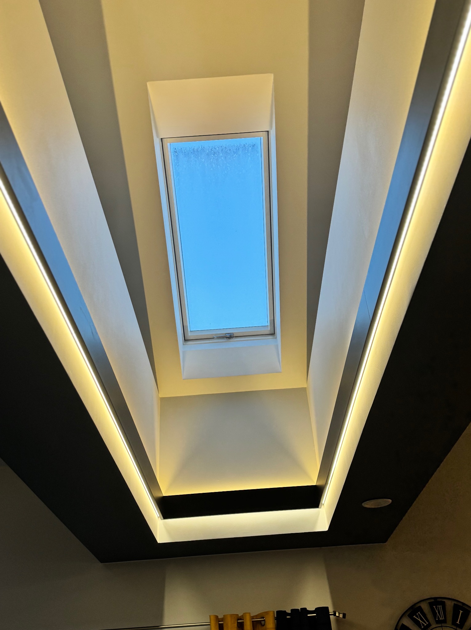 Sufit z oknem dachowym i dekoracyjnym oświetleniem LED, widok z dołu.