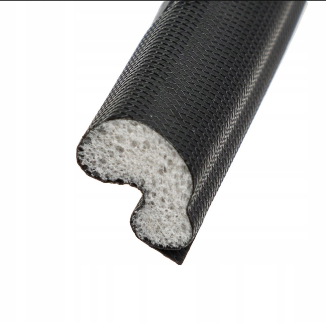 Uszczelka okienna z porowatej gumy o charakterystycznym profilu, czarna powierzchnia zewnętrzna z delikatną fakturą, na białym tle.