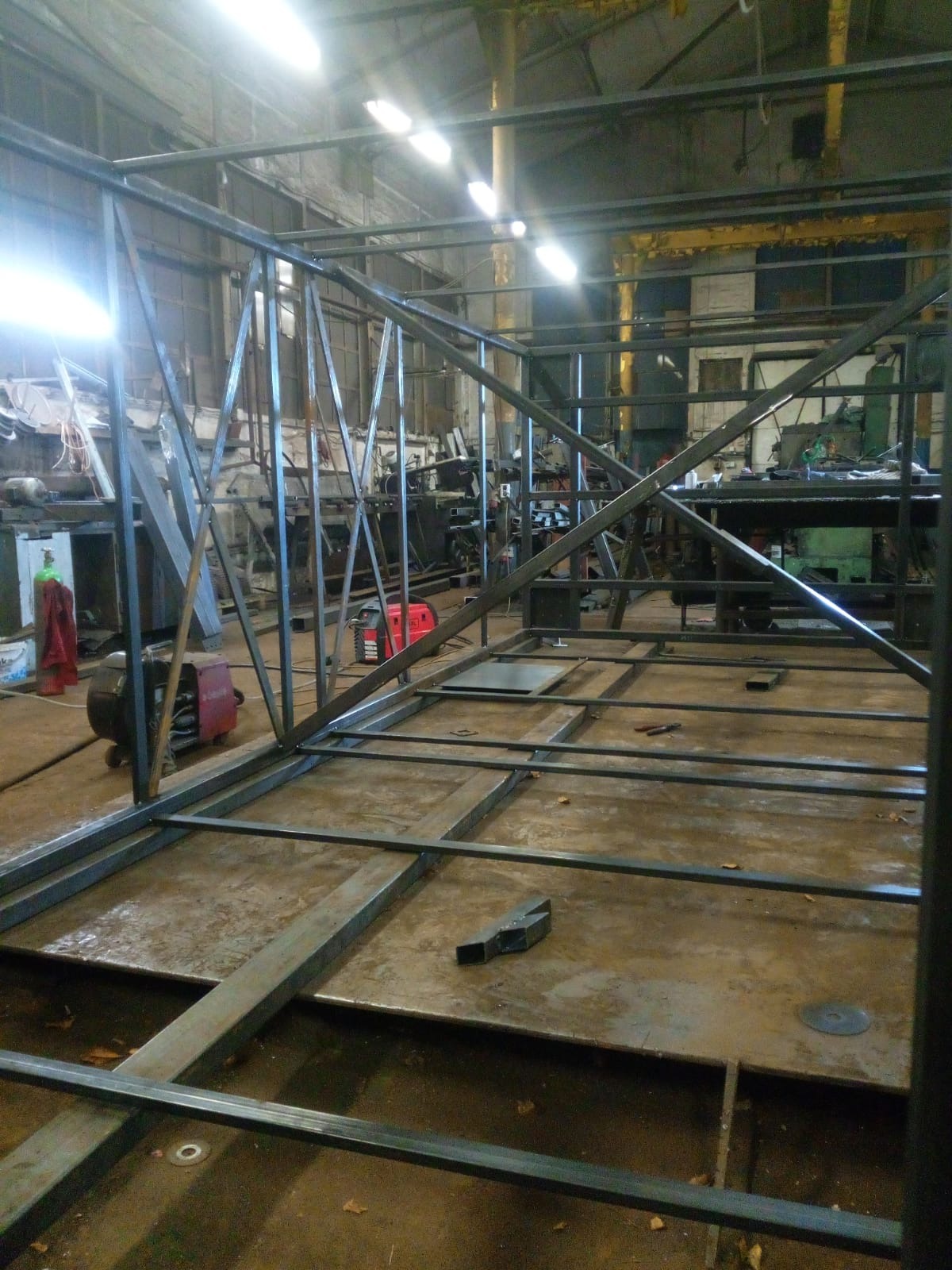 Konstrukcja szkieletowa z metalowych profili w warsztacie w Bytomiu, widoczne spawarki i narzędzia w tle.