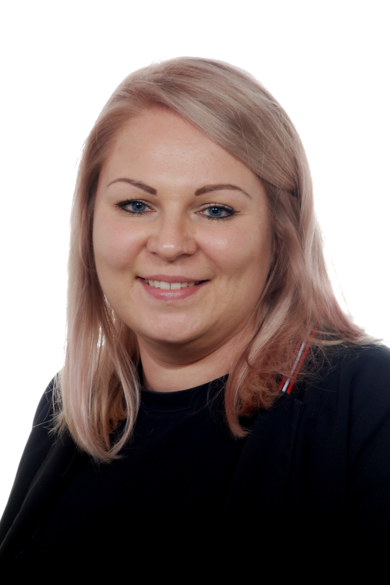 Portret uśmiechniętej kobiety z blond włosami, ubrana w czarną bluzkę, na białym tle.