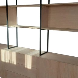 Przedsiębiorstwo Techniczne MTC Wiktor Suska - Regał z jasnego drewna z czarnymi metalowymi elementami konstrukcyjnymi, oświetlony promieniami słonecznymi tworzącymi cienie na powierzchni szafek.