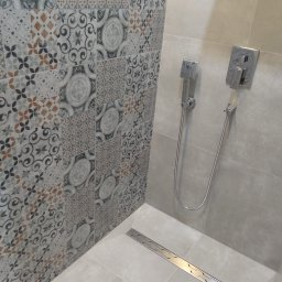 METAINVEST SPÓŁKA Z OGRANICZONĄ ODPOWIEDZIALNOŚCIĄ - Wzorzyste płytki ścienne i natrysk w nowoczesnej łazience we Wrocławiu. Uwagę przykuwa liniowy odpływ podłogowy i minimalistyczna armatura.