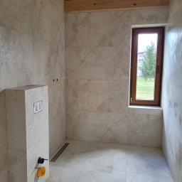 OKSANA TKACHUK - Jasna, wykafelkowana łazienka z drewnianym stropem, oknem z widokiem na zieleń, zabudową WC i odpływem liniowym w podłodze.