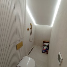 STYL DREAM HOME SPÓŁKA Z OGRANICZONĄ ODPOWIEDZIALNOŚCIĄ - Nowoczesna toaleta podwieszana z ukrytą spłuczką, złotą armaturą i oświetleniem LED w suficie, widoczny mop Vileda.