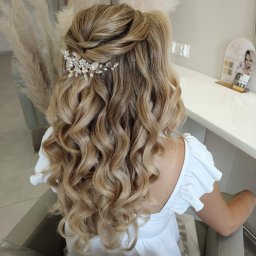 sTyLove Upięcia Studio Pielęgnacji Włosów EWELINA STANKIEWICZ - Upięcie ślubne z loków, ozdobione spinką z kryształkami i perłami, widok z tyłu na blond włosy w salonie fryzjerskim.