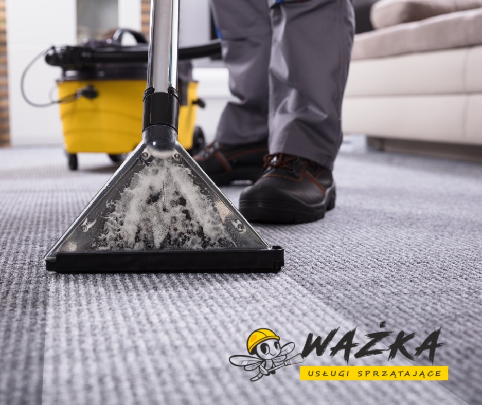 Czyszczenie dywanu odkurzaczem piorącym, widoczna piana i urządzenie z żółtym zbiornikiem, logo firmy sprzątającej w prawym dolnym rogu.