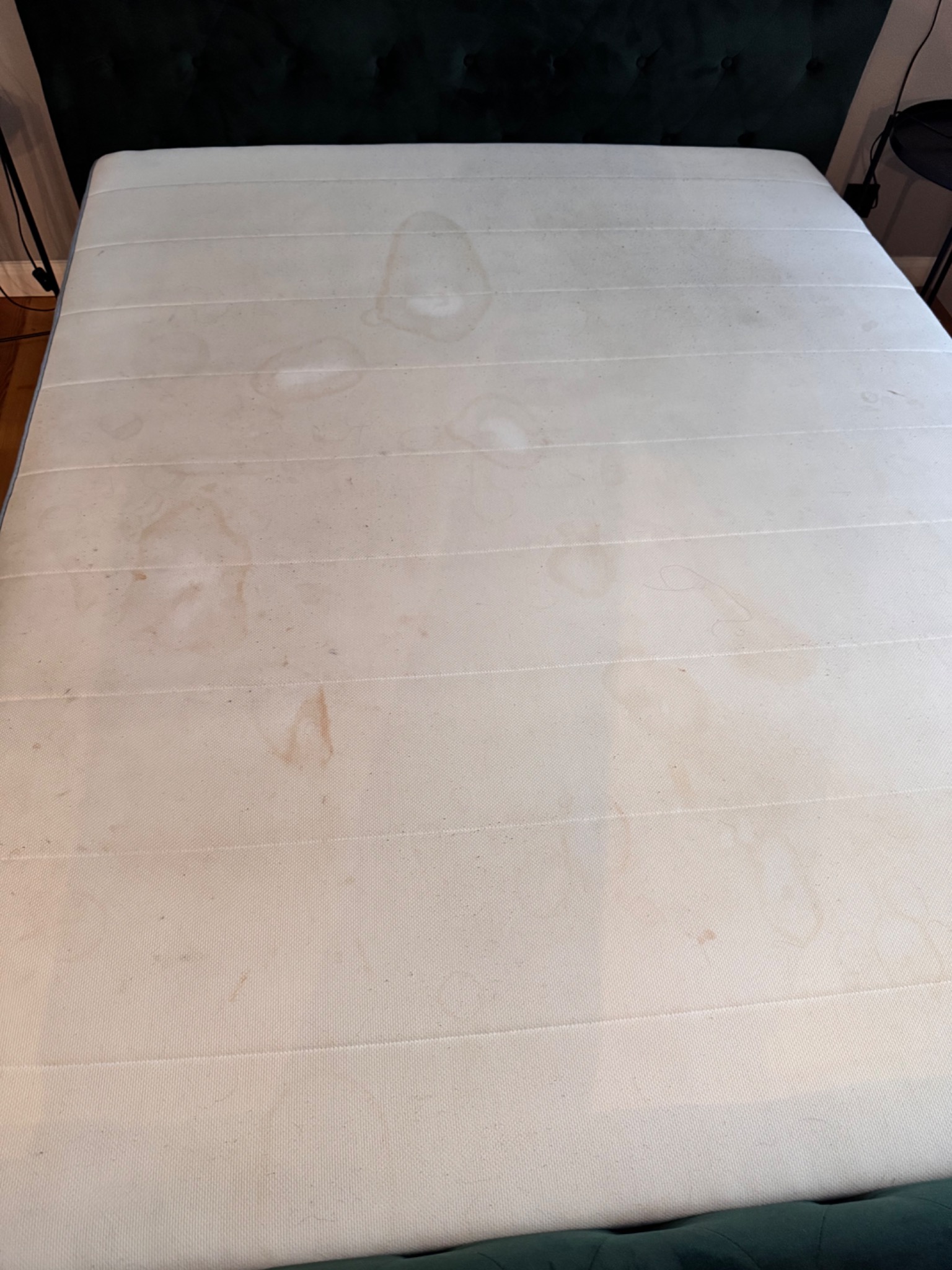 Materac z widocznymi plamami i zabrudzeniami, ukazujący potrzebę profesjonalnego czyszczenia tapicerki.