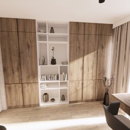 PROSVERO SPÓŁKA Z OGRANICZONĄ ODPOWIEDZIALNOŚCIĄ - Nowoczesny gabinet z drewnianą zabudową, białym regałem i biurkiem przy oknie. Minimalistyczny wystrój z akcentami roślinnymi i stonowaną kolorystyką.