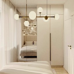 PROSVERO SPÓŁKA Z OGRANICZONĄ ODPOWIEDZIALNOŚCIĄ - Nowoczesna sypialnia z lustrem powiększającym przestrzeń, designerskie lampy kuliste i minimalistyczna szafa w zabudowie. Całość utrzymana w jasnej tonacji.