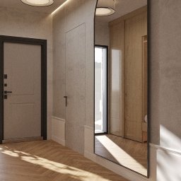 PROSVERO SPÓŁKA Z OGRANICZONĄ ODPOWIEDZIALNOŚCIĄ - Nowoczesny przedpokój z lustrem w czarnej ramie, drewnianą podłogą w jodełkę i minimalistycznym oświetleniem sufitowym. Widoczne drzwi wejściowe i szafa wnękowa.