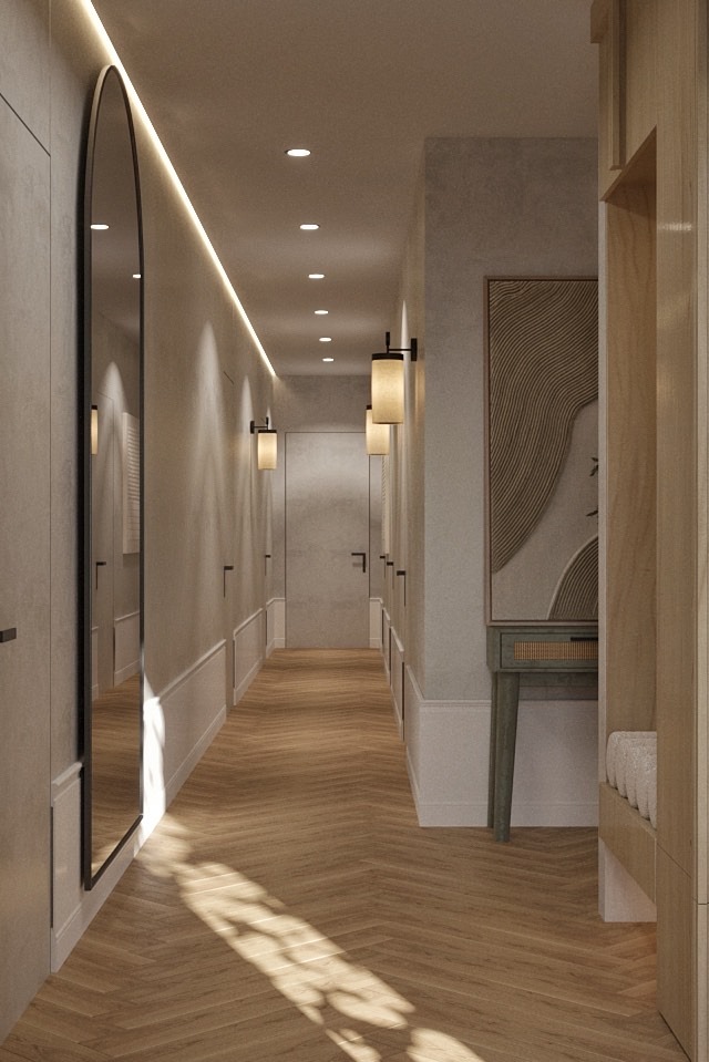 Długi korytarz w neutralnych barwach z parkietem w jodełkę, oświetleniem punktowym i dekoracyjnym lustrem. Widoczne detale wykończenia ścian i minimalistyczne lampy.